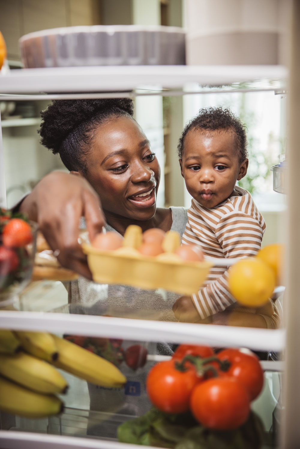 Woman and child looking inside refrigerator together