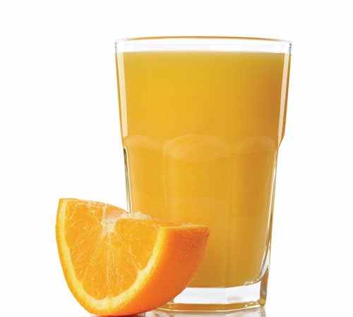 Glass of orange juice with fresh orange slice.