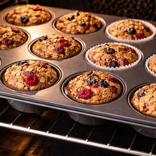 Baked oat muffins with berries in oven tray