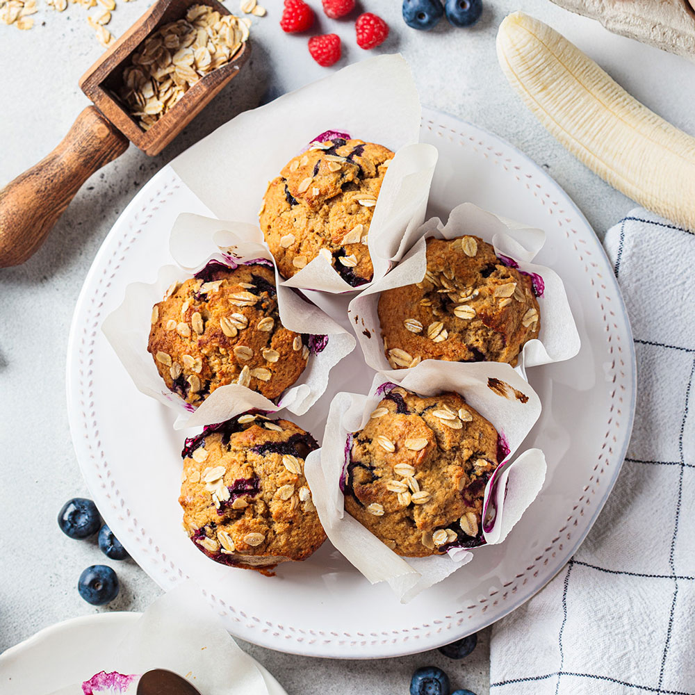 Five blueberry muffins with oats on a white plate